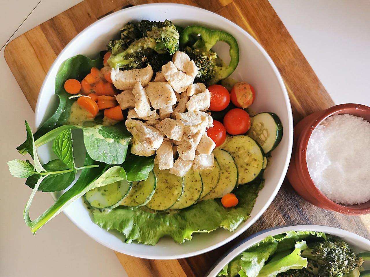 Overhead view of a nutritious vegetable salad with chicken, perfect for a healthy meal.